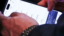 Waltz looks at what appears to be a messaging app on his phone