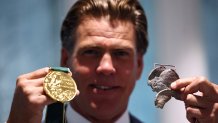 US swimmer Gary Hall Jr.   holds one of the original medals as he is presented with repilicas of his Olympic medals by  IOC President Thomas Bach during a handover ceremony after the originals were destroyed with his house in the Los Angeles wildfires earlier this year, at the Olympic House in Lausanne on May 5, 2025. (Photo by Denis Balibouse / POOL / AFP) (Photo by DENIS BALIBOUSE/POOL/AFP via Getty Images)