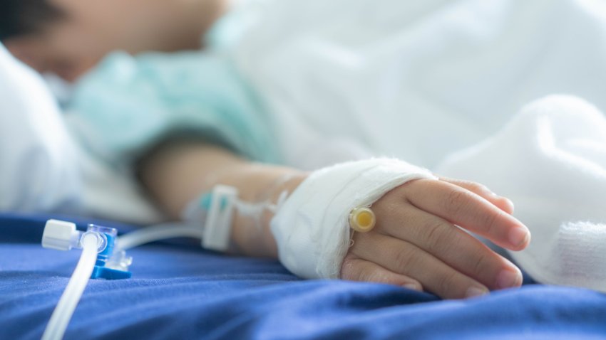 an Asian todler in hospital with intravenous saline. Sick children, infected with the virus, are lying and being treated in beds in hospitals.