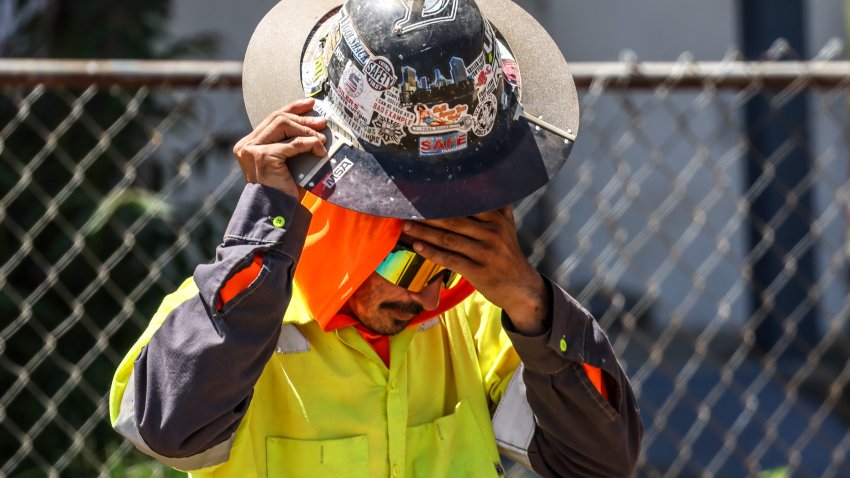 Pomona, CA, Tuesday, May 20, 2025 – Joey Navarro,of Gentry Bros. Construction pauses to wipe sweat as he does road work for the city of Pomona at 9th and Park.   (Robert Gauthier/Los Angeles Times via Getty Images)