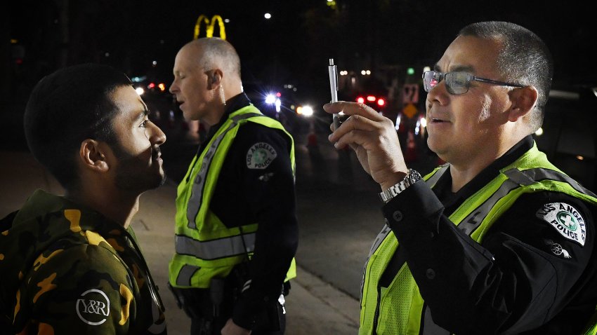 A man undergoes a sobriety test before being detained at a LAPD police DUI checkpoint in Reseda, Los Angeles, California on April 13, 2018. Pot may be legal in eight US states and the capital, but tokers getting behind the wheel on a national weed appreciation day could be in for a downer as police forces crack down on intoxicated drivers. In places like California, where recreational marijuana has been legal since January, law enforcement officials and doctors are worried about an increase in people arrested for erratic driving and hospitalized with overdoses. The issue is particularly acute on April 20, or 4/20, a national day of celebration in cannabis culture — especially after 4:20 pm when usage surges. (Photo by Mark RALSTON / AFP) (Photo by MARK RALSTON/AFP via Getty Images)