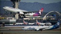 An Alaska Airlines plane and a Hawaiian Airlines plane at Los Angeles International Airport in Los Angeles on Dec. 5, 2023.