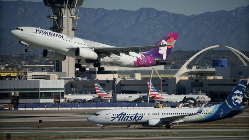 An Alaska Airlines plane and a Hawaiian Airlines plane at Los Angeles International Airport in Los Angeles on Dec. 5, 2023.