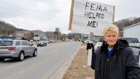 Swannanoa resident Lucy Bickers, who received assistance from FEMA after Hurricane Helene damaged her property, holds a sign in support of the government disaster agency as she waits on the route of visiting U.S. President Donald Trump’s motorcade in Swannanoa, North Carolina, U.S., January 24, 2025. 