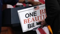 Staff members remove a sign following a press conference after the House passage of the tax and spending bill, at the U.S. Capitol on May 22, 2025 in Washington, DC.