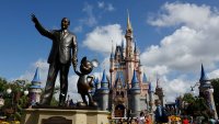 A statue of Walt Disney and Mickey Mouse stands in a garden in front of Cinderella’s Castle at the Magic Kingdom Park at Walt Disney World on April 3, 2025, in Orlando, Florida.