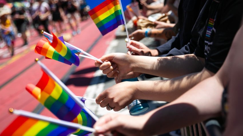 Parade goers hold Pride flags during the annual Pride Parade in San Francisco on Sunday, June 29, 2024.