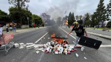 PARAMOUNT, CA - JUNE 7, 2025: People block off Alondra Blvd. and set a fire during protests against ICE and immigration raids, in Paramount, Ca., on Friday, June 7, 2025. (Myung J. Chun / Los Angeles Times via Getty Images)