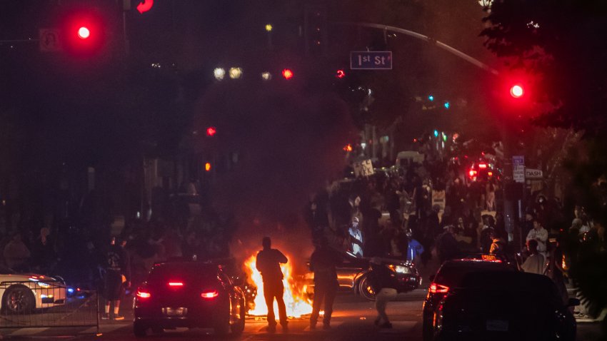 LOS ANGELES, CALIFORNIA – JUNE 08: Protesters set trash cans on fire in front of City Hall during clashes with the police on June 08, 2025 in Los Angeles, California. Tensions in the city remain high after the Trump administration called in the National Guard against the wishes of city leaders following two days of clashes with police during a series of immigration raids. (Photo by Apu Gomes/Getty Images)