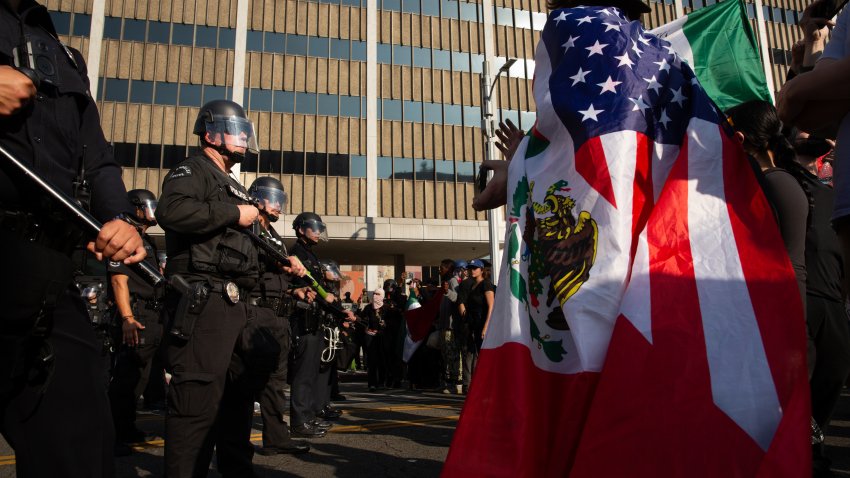 10 June 2025, US, Los Angeles: A picture made available on June 11, 2025 shows a demonstrator wearing a half Mexican half US flag as a cape, during a protest against immigration raids conducted by ICE and Federal police, in front of the US Department of Homeland Security-Immigration and Customs Enforcement building in Los Angeles. Photo: Zin Chiang/dpa (Photo by Zin Chiang/picture alliance via Getty Images)