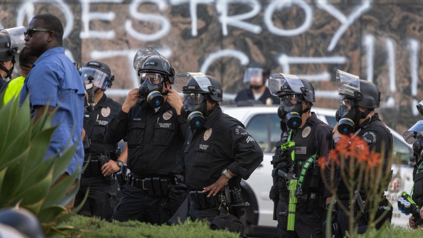 LOS ANGELES, CALIFORNIA – JUNE 14: Police stand near officers repeatedly shooting people with less-than-lethal munitions during a “No Kings” movement protest in the one-square mile area where daily protests have been occurring in response to a series of federal immigration raids on June 14, 2025 in Los Angeles, California. Hundreds of marches and protests against the Trump administration are happening across the United States in opposition to Trump policies on the same day as President Trump’s 79th birthday and a military parade on the 250th anniversary of the U.S. Army in Washington, DC. (Photo by David McNew/Getty Images)