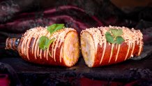 Halloween Time at the Disneyland Resort in Anaheim, Calif. begins Aug. 22, 2025 to Oct. 31, 2025. The Fried Elote on the Cob at Corn Dog Castle: Whole corn cob dipped in batter and fried to golden brown and drizzled with chipotle aioli topped with chile-lime queso fresco and cilantro. (David Nguyen/Disneyland Resort)