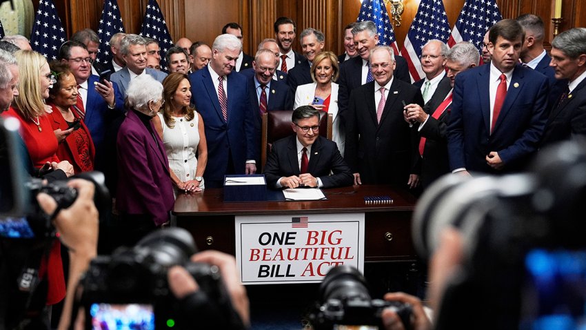 Speaker of the House Mike Johnson, R-La., surrounded by Republican members of Congress, signs President Donald Trump's signature bill of tax breaks and spending cuts, Thursday, July 3, 2025, at the Capitol in Washington.