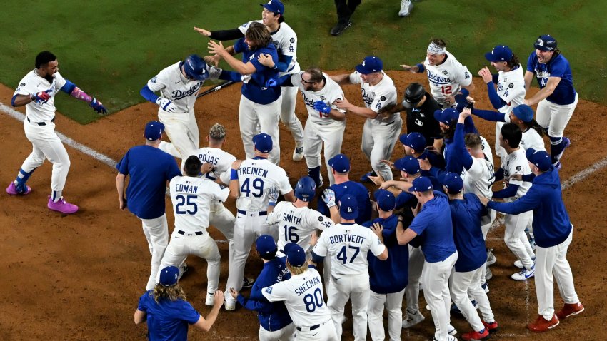 Freddie Freeman of the Los Angeles Dodgers is mobbed by teammates after hitting a walk off solo home run to defeat the Toronto Blue Jays 6-5 and win Game 3 of the 2025 World Series at Dodger Stadium in Los Angeles on Monday, Oct. 27, 2025.