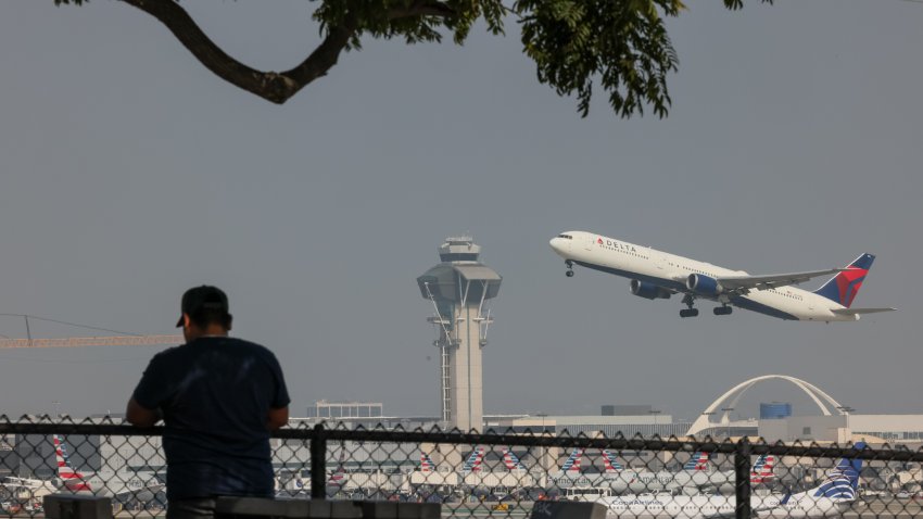 FILE -- A spectator watches as a Delta Airlines flight takes off as seen from Clutter's Park on Sunday, Oct. 26, 2025 in El Segundo, CA.
