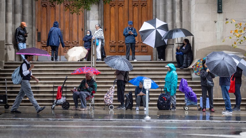 Los Angeles, CA – November 14: Los Angeles residents wait in line in the rain at Immanuel Presbyterian Church’s weekly food pantry as the Southland is drenched by storms on Friday, Nov. 14, 2025 in Los Angeles, CA. (Jason Armond / Los Angeles Times via Getty Images)