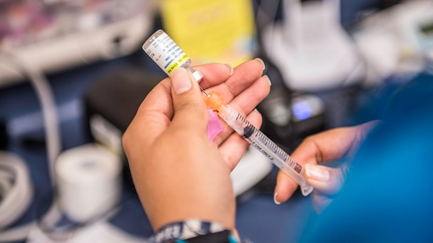 File - A certified medical assistant fills a syringe with a drug used for HPV vaccinations on May 27, 2016.