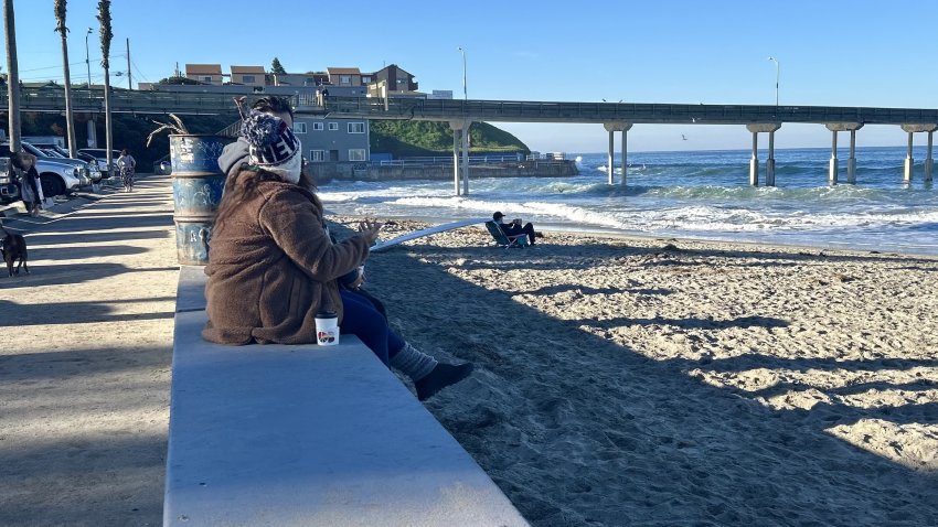 Beachgoers can only look at the OB Pier from a distance, Sunday morning. No one has been allowed on it in more than two years, Ocean Beach, Calif., December 7, 2025.