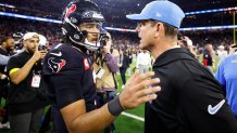 HOUSTON, TEXAS - JANUARY 11: C.J. Stroud #7 of the Houston Texans and head coach Jim Harbaugh of the Los Angeles Chargers embrace on the field after their game during the AFC Wild Card Playoffs at NRG Stadium on January 11, 2025 in Houston, Texas. (Photo by Tim Warner/Getty Images)