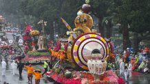 People ride on the Trader Joe's "You Float Our Boat!" float in the rain during the 137th Rose Parade on New Years Day in Pasadena, California, on January 1, 2026. The parade features floral floats, marching bands and equestrian units to ring in the New Year along the 5.5 mile (8.8 km) route along Colorado Blvd in Pasadena. (Photo by Patrick T. Fallon / AFP via Getty Images)