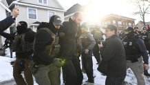 MINNEAPOLIS, MINNESOTA - JANUARY 13:  An observer is detained by ICE agents after they arrested two people from a residence on January 13, 2026 in Minneapolis, Minnesota. The Trump administration has deployed over 2,400 Department of Homeland Security agents to the state of Minnesota in a push to apprehend undocumented immigrants. (Photo by Stephen Maturen/Getty Images)