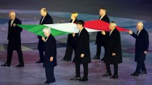 Flagbearers Luca Gandini, Rudolf Wieser, Marinella Canclini, Luca Moretti, Fabio Morandini, Sergio Longo, Luca Braga, and Bice Passera carry the Italian flag during the Milano Cortina 2026 Winter Olympics Closing Ceremony.