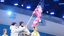 Flagbearers Evan Bates and Hilary Knight of Team United States wave the U.S. flag.