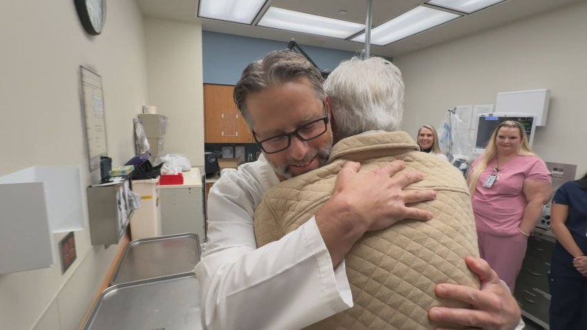 Two men hugging while others look on