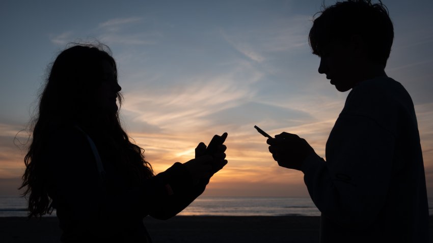 SENNEN, UNITED KINGDOM – JUNE 01: In this photo illustration a 15-year-old teenage girl and a 15-year-old teenage boy looks at an iPhone smartphone screen as the sun sets on June 1, 2026 in Cornwall, England. UK Prime Minister Keir Starmer has announced a ban on social media for under-16s following a similar Australian law which aims to stop children under 16 from having social media accounts and social media platforms, including TikTok, Facebook, Snapchat, Reddit, X, formerly Twitter, and Instagram. (Photo by Anna Barclay/Getty Images)