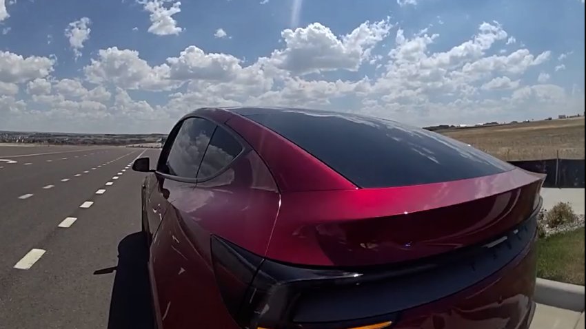 Red Tesla on shoulder of highway