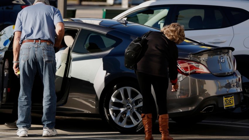 Potential car buyers view a Hyundai Motor Co. Genesis luxury vehicle on the lot of the Keyes Hyundai dealership in the Van Nuys neighborhood of Los Angeles, California, U.S., on Saturday, Jan. 2, 2016.