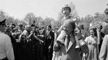 President Jimmy Carter holds his two-year-old grandson, Jason Carter, on his shoulders while visiting the South Lawn on April 11, 1977, for the Easter Egg Roll at the White House in Washington.