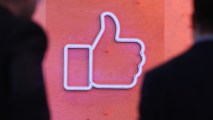 In this February 24, 2016 file photo, people walk past the Facebook "Like" symbol at the Facebook Innovation Hub Berlin, Germany.